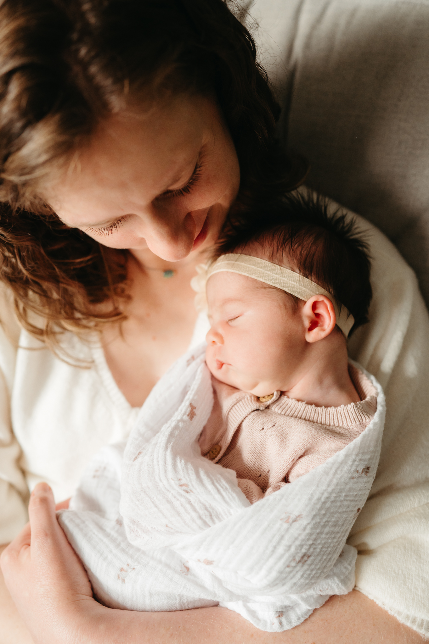 Lifestyle in-home newborn photography capturing a candid moment of a baby in a nursery setting, with soft natural lighting and personal details.