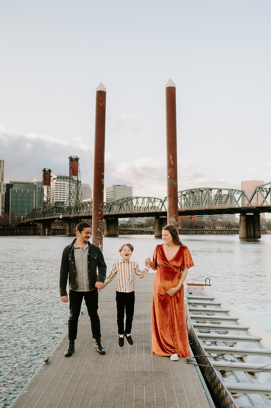 Stylish family walking together in an urban setting, wearing mustard and rust tones. A modern and vibrant family photography session with movement and joy.