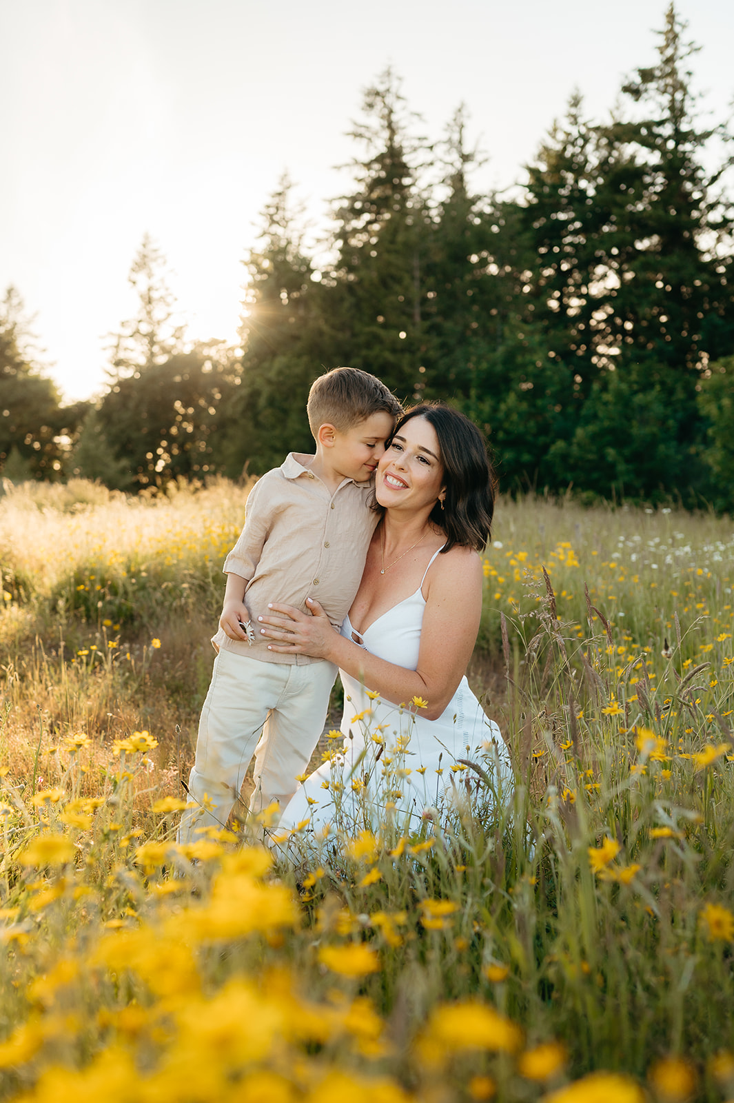 mother and sun snuggling in a field of daisies 