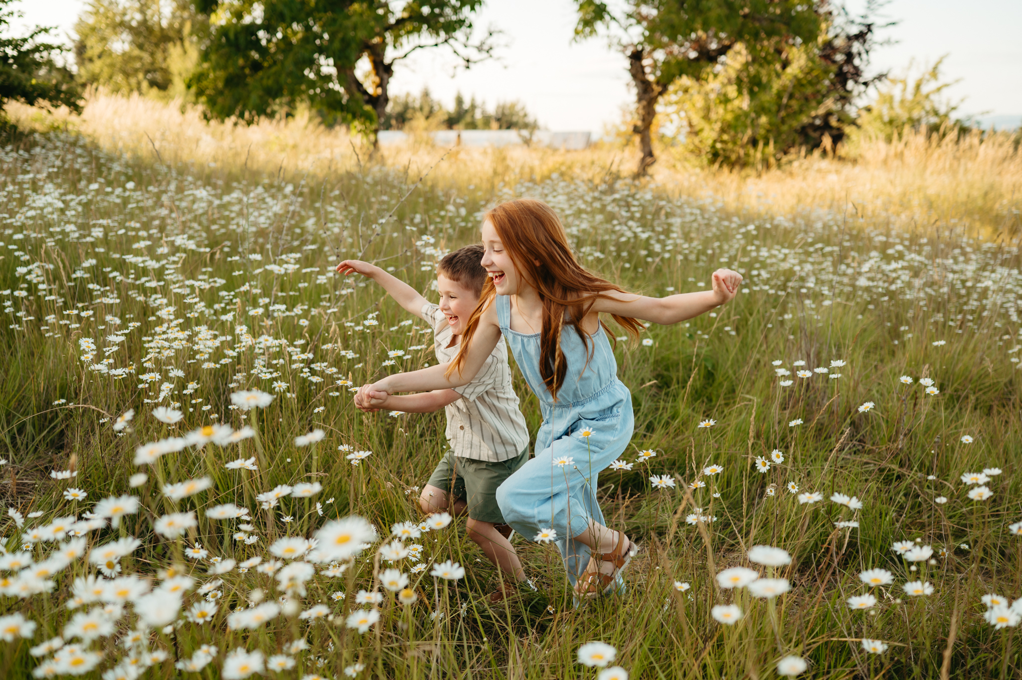 portland oregon family siblings running joyfully through a field of daisies