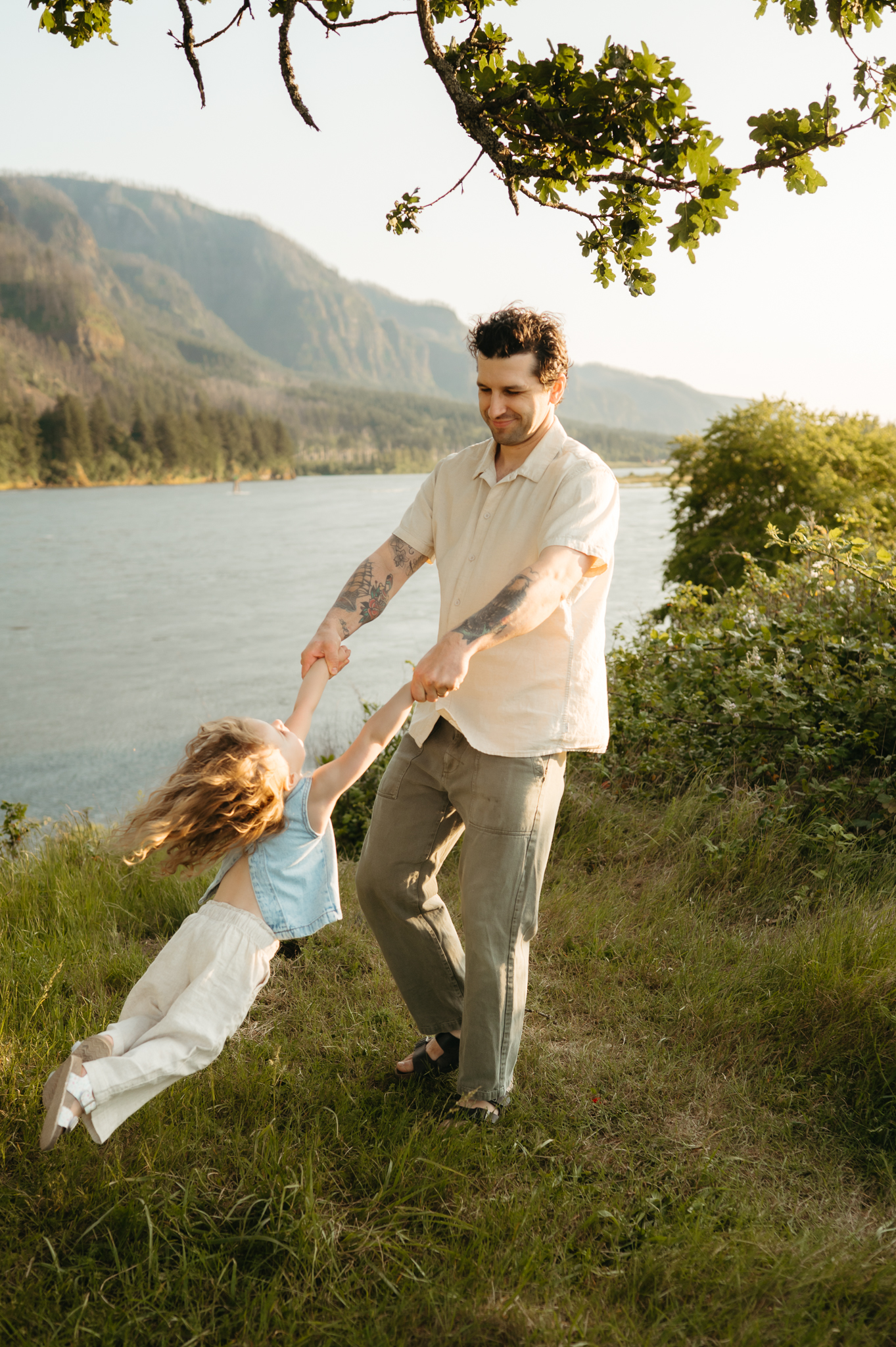 dad spinning little girl around in the columbia river gorge at golden hour