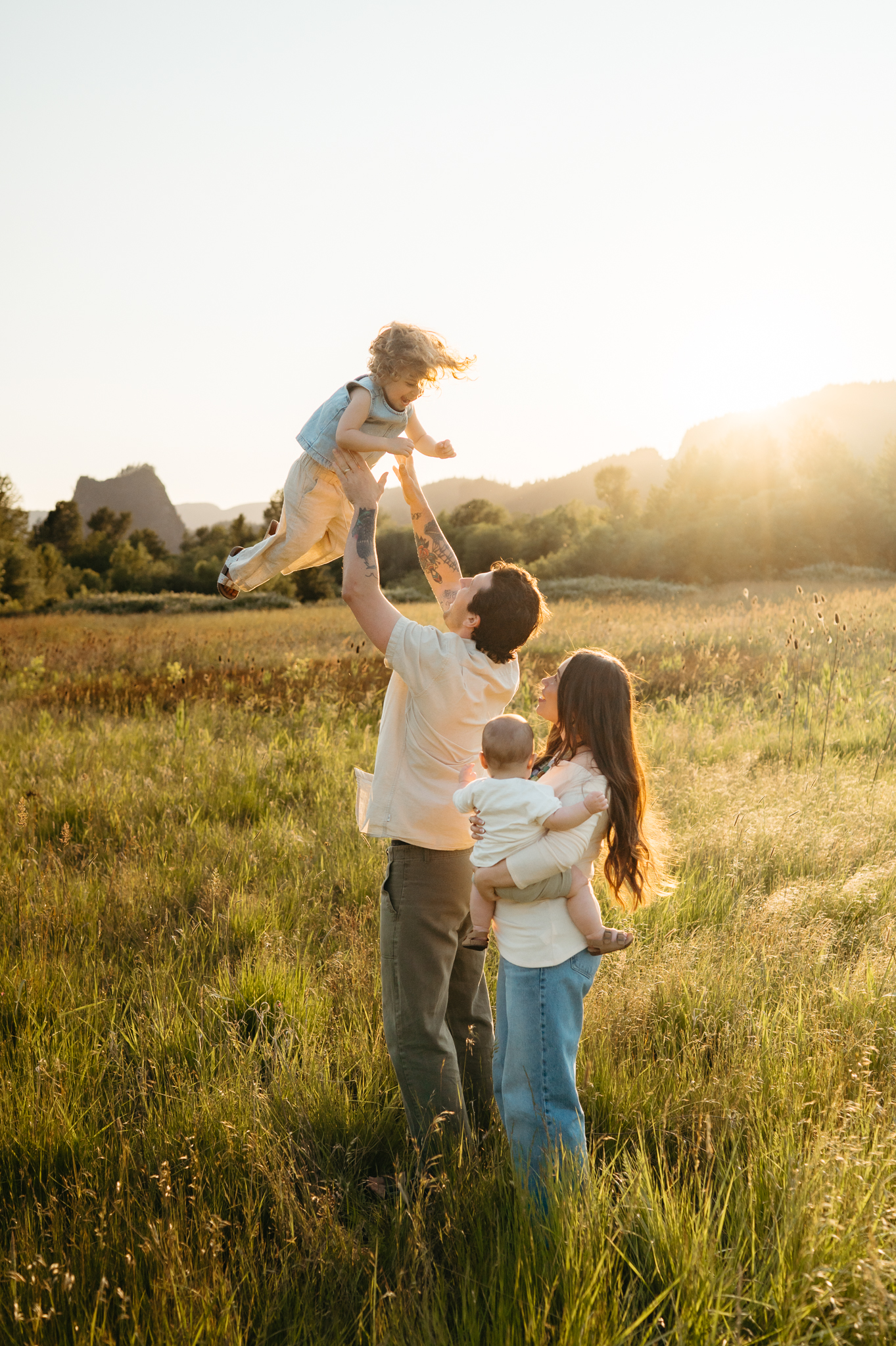 portland family in the columbia river gorge during golden hour, tossing little girl up in the air